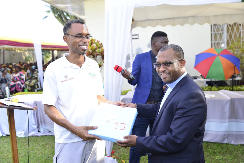 The outgoing JCAM President, Rev. Fr. Agbonkhianmeghe E. Orobator S.J. being presented with a gift by Fr. Ismael Matambura S.J. during AJAN 2Oth Anniversary at Servuce Yezu Mwiza in Bujumbura Burundi on 6th June 2022.