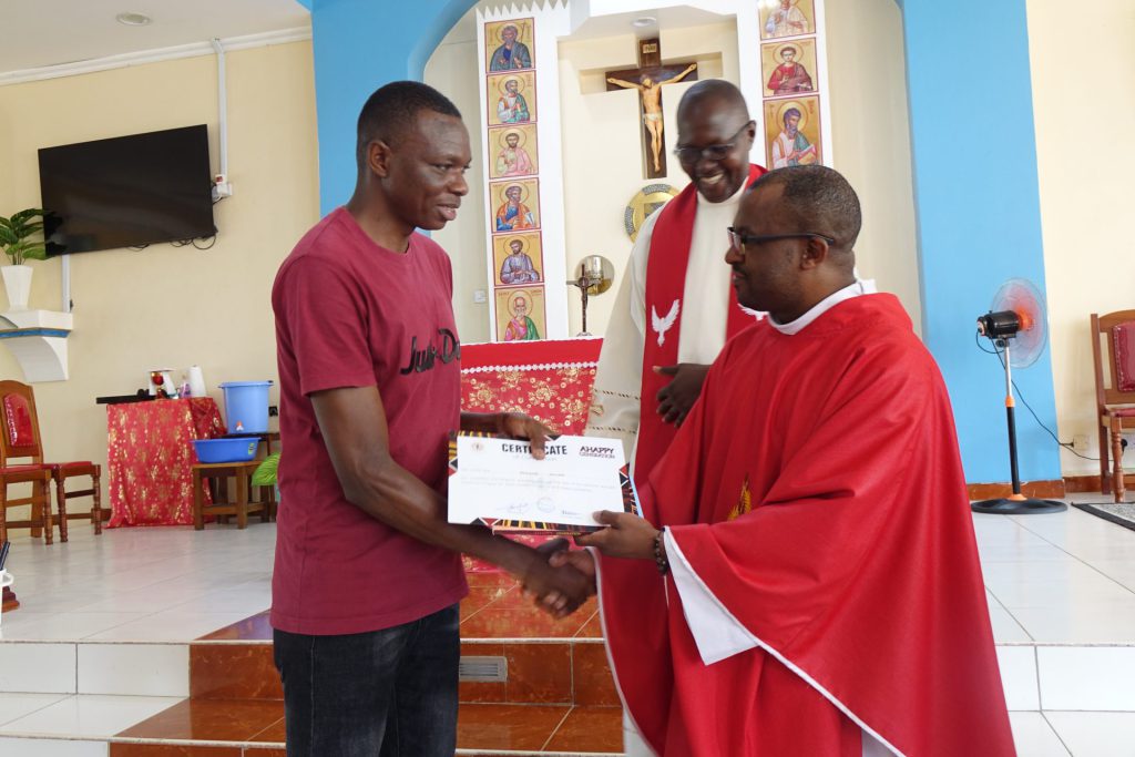 Le gendarme Bonface Mulinge reçoit le certificat AHAPPY des mains du Père Ismael Matambura SJ.